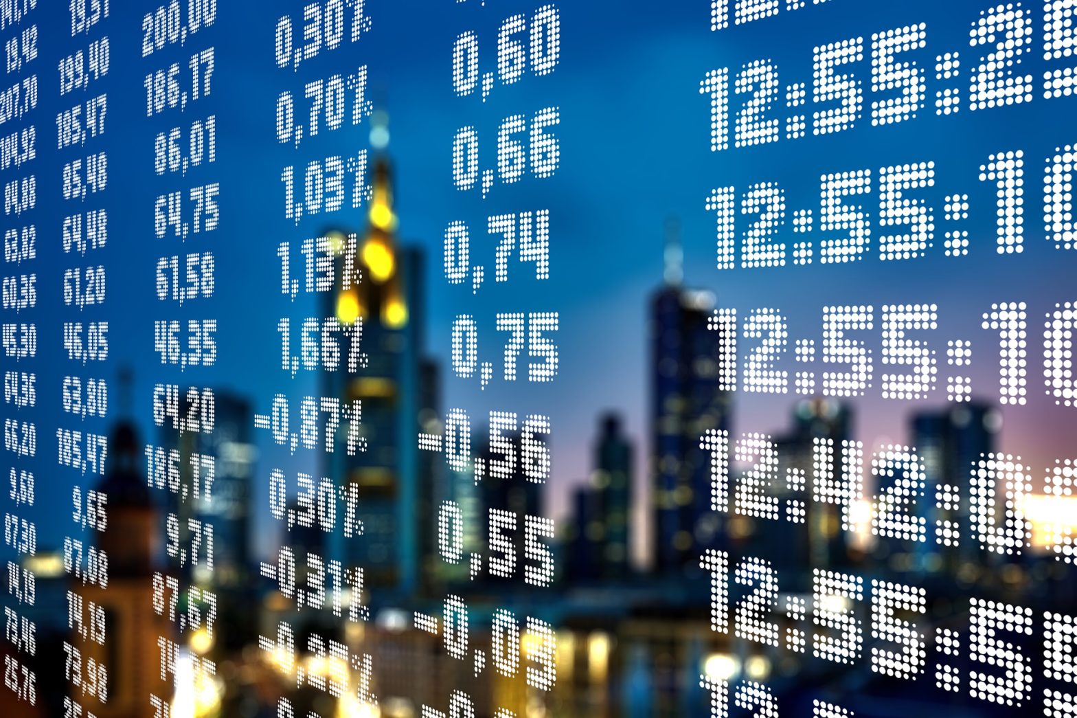 Börsenkurse im Display mit Wolkenkratzern im Hintergrund
